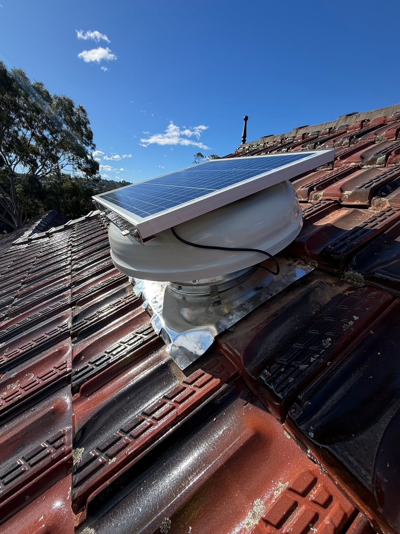 SolarWhiz ventilator and solar panel installed on a tiled roof in Longueville