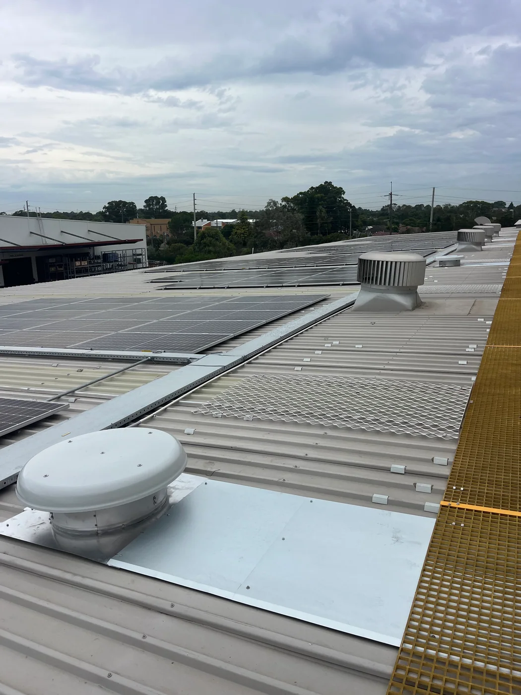 Commercial rooftop with solar panels and existing ventilation equipment